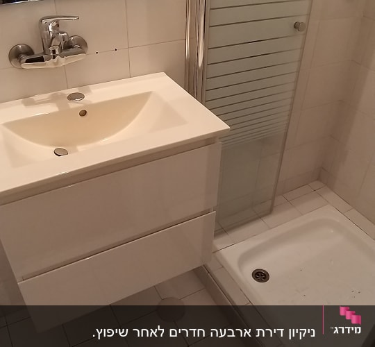 כיור ומקלחון בחדר אמבטיה נקי ומסודר